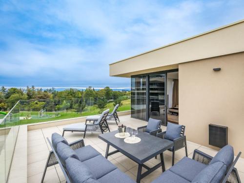 a patio with blue chairs and a table on a balcony at Holiday Home Semi-detached Villa Crveni vrh 1-2-3- by Interhome in Savudrija