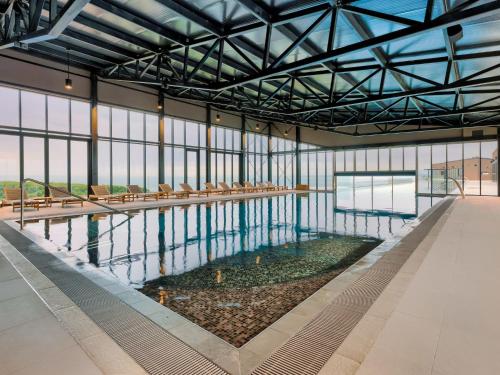 a large indoor swimming pool with chairs in a building at Holiday Home Semi-detached Villa Crveni vrh 1-2-3- by Interhome in Savudrija