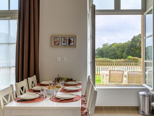 een eetkamer met een witte tafel en een raam bij Apartment Le Château de Kergonano-9 by Interhome in Baden