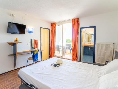 une chambre avec un grand lit blanc et un balcon dans l'établissement Apartment Le Neptune-4 by Interhome, à Saint Pierre La Mer
