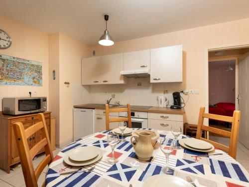 une cuisine avec une table avec des assiettes et des verres dessus dans l'établissement Apartment L'air du Large by Interhome, à Saint-Malo