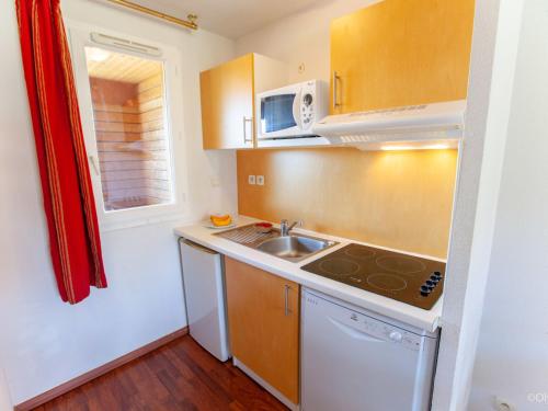 a small kitchen with a sink and a microwave at Apartment Les Hameaux de La Chalosse-2 by Interhome in Cassen