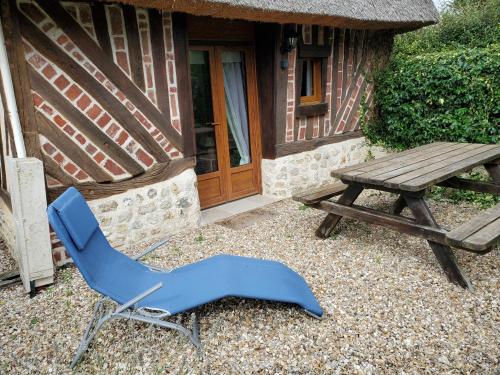 a blue chair next to a wooden table and a picnic table at La Griotte & Spa&Piscine in Pennedepie