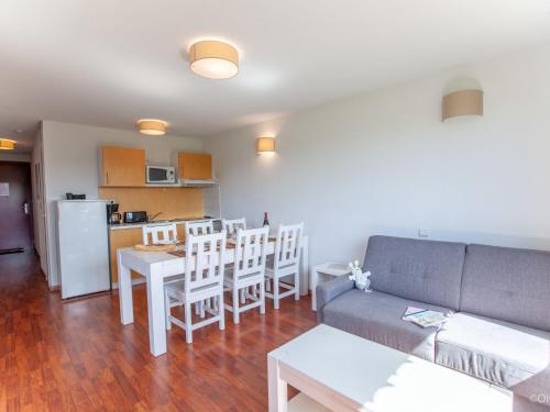 Apartment Les Hameaux de La Chalosse-3 by Interhome في Cassen: غرفة معيشة مع أريكة وطاولة وكراسي