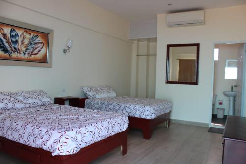 una camera d'albergo con due letti e uno specchio di OceanSide Hotel & Pool a Bayahibe