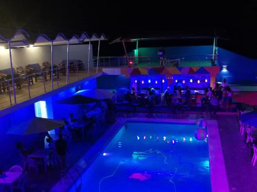 una piscina por la noche con gente sentada alrededor en OceanSide Hotel & Pool en Bayahibe