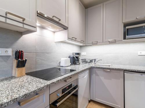 une cuisine avec des armoires blanches et un comptoir dans l'établissement Apartment Le Hameau du Borsat - Val Claret-14 by Interhome, à Tignes