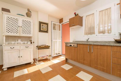 uma cozinha com armários de madeira e piso em azulejo em Spikes em Guadiaro