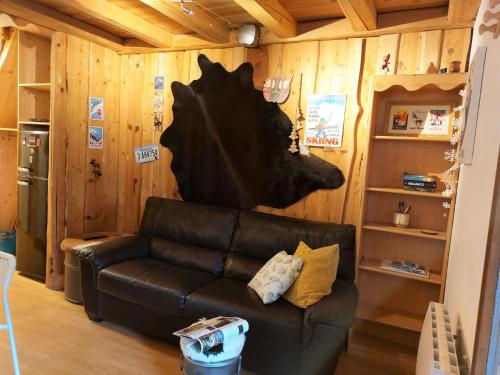 - un salon avec un canapé en cuir noir et des murs en bois dans l'établissement Apartment Les Hauts de Saint Gervais-11 by Interhome, à Saint-Gervais-les-Bains