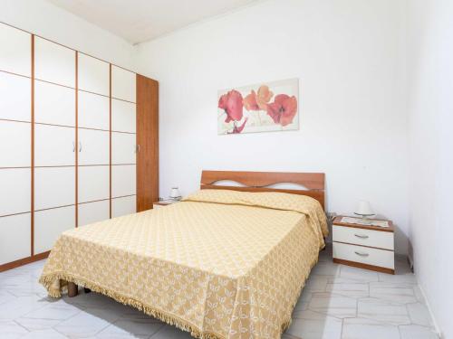 Un dormitorio con una cama con una colcha amarilla. en Holiday Home Enrica by Interhome, en Marina di Mancaversa