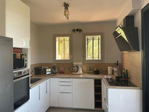 une cuisine avec des armoires blanches et un micro-ondes dans l'établissement Villa Les Oliviers by Interhome, à La Valette-du-Var