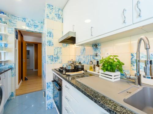 a kitchen with blue and white tiles on the walls at Apartment The LightHouse by Interhome in Albufeira