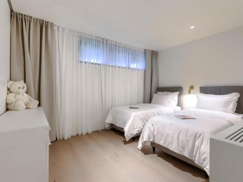 a bedroom with two beds and a teddy bear at Holiday Home Semi-detached Villa Crveni vrh 1-2-3- by Interhome in Savudrija