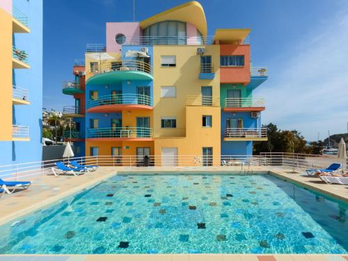 a hotel with a swimming pool in front of a building at Apartment The LightHouse by Interhome in Albufeira