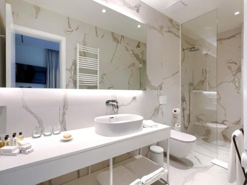 a white bathroom with a sink and a toilet at Holiday Home Semi-detached Villa Crveni vrh 1-2-3- by Interhome in Savudrija