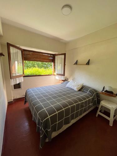 a bedroom with a bed and a large window at Pinamar departamento in Pinamar