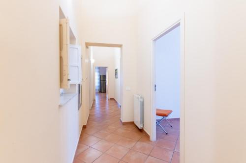 un pasillo con paredes blancas y una silla en una habitación en Viola's Luxury House en Palermo
