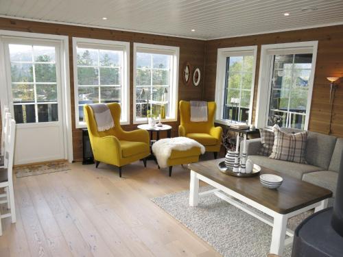 a living room with yellow chairs and a couch at Holiday Home Bortebu - SOW139 by Interhome in Åseral