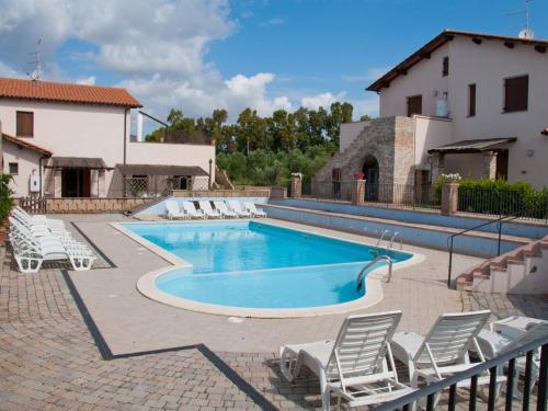 een zwembad met stoelen en een huis bij Apartment Borgo Valmarina-3 by Interhome in Carbonifera