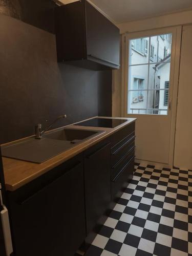 a kitchen with a sink and a checkered floor at Süsse Wohnung in Zürcher Altstadt 3 in Zürich