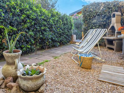 ein Liegestuhl und Topfpflanzen in einem Garten in der Unterkunft Apartment Happy Island by Interhome in Badesi