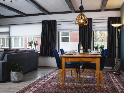 a dining room with a table and blue chairs at Apartment Delfzijl by Interhome in Delfzijl