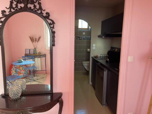 La salle de bains est pourvue d'un miroir, d'une table et d'une cuisine. dans l'établissement Desert de Ouarzazatte paris orly, à Vigneux-sur-Seine