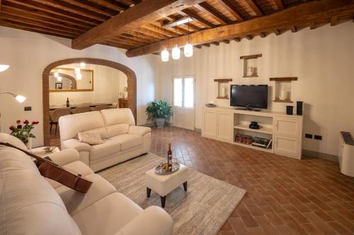 een woonkamer met een bank en een tv bij Agriturismo Santo Stefano in Polvano