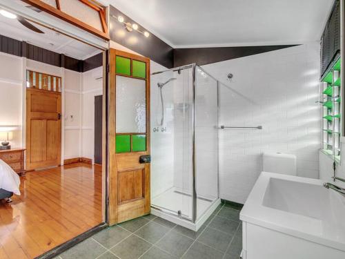 a bathroom with a shower and a toilet and a sink at Historic Character-filled Jade Cottage in Coalfalls