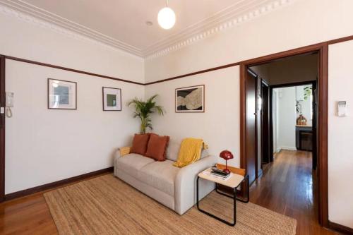 a living room with a couch and a table at Charming Art Deco Unit in East Melbourne in Melbourne