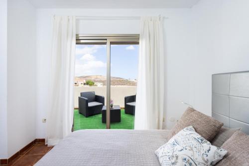 エル・メダノにあるRiver Vista Marinaのベッドルーム1室(ベッド1台付)、スライド式ガラスドアが備わります。