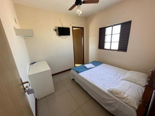 ein Schlafzimmer mit einem Bett und einem TV in der Unterkunft HOTEL VARGINHA II in Varginha