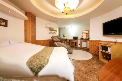 a bedroom with a large bed and a flat screen tv at Cheonan Business Hotel in Cheonan