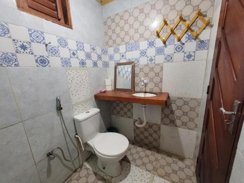 a bathroom with a toilet and a sink at Vila Coqueiro - Moitas in Amontada
