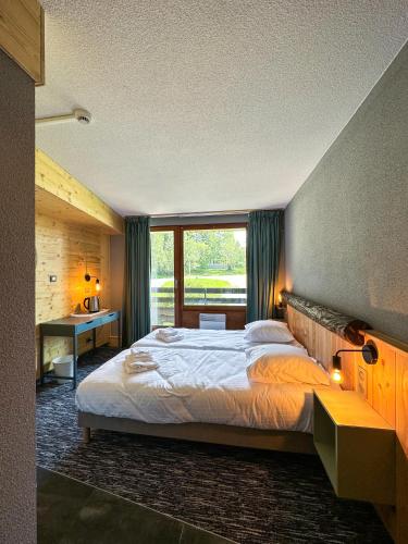 a bedroom with a large bed and a window at Le Motel du Gaschney in Muhlbach-sur-Munster