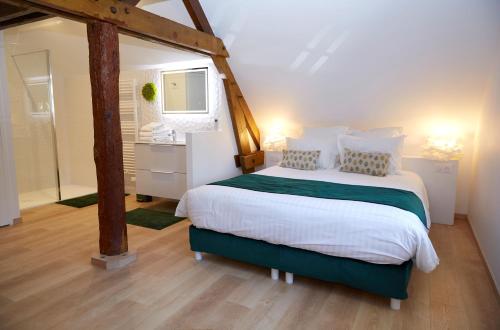 a bedroom with a large bed and a bathroom at La Bertonnerie en Champagne in Prunay