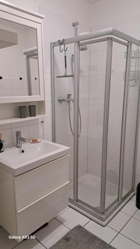 een witte badkamer met een douche en een wastafel bij small Stable - charmantes Häuschen Mitten in Lemgo in Lemgo
