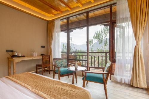 a bedroom with a bed and a table and chairs at Sand Dunes Retreat in Leh