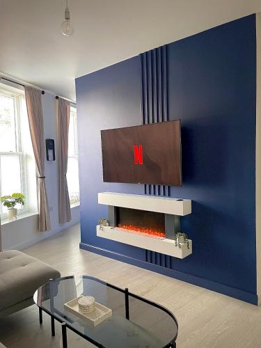 een woonkamer met een tv boven een open haard bij Central 2-bedroom apartment, Montrose in Montrose