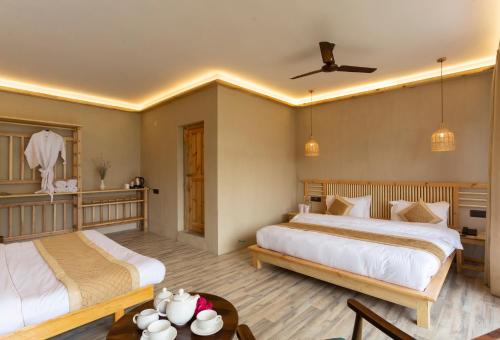 a bedroom with two beds and a table at Sand Dunes Retreat in Leh
