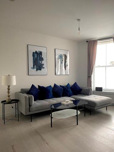 - un salon avec un canapé et des oreillers bleus dans l'établissement Central 2-bedroom apartment, Montrose, à Montrose