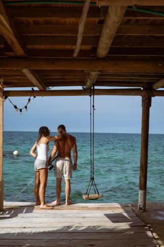 a man and a woman standing on a dock in the water at Hostel Santa Cruz del Islote in Santa Cruz del Islote