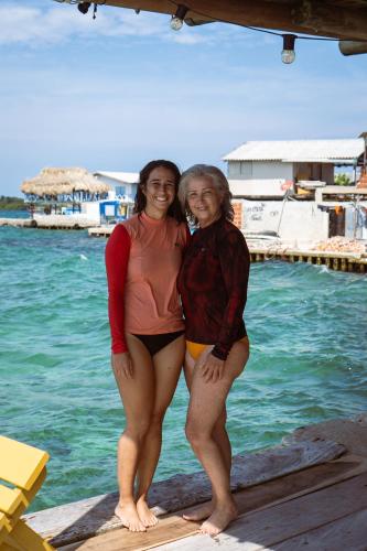 two women standing on a dock in the water at Hostel Santa Cruz del Islote in Santa Cruz del Islote