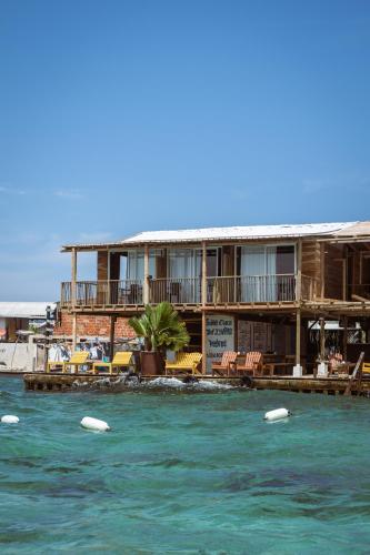 a building on the water with surfboards in the water at Hostel Santa Cruz del Islote in Santa Cruz del Islote