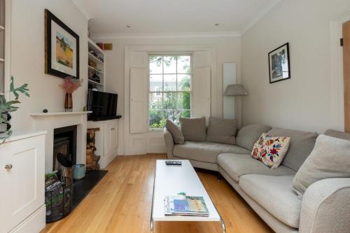 - un salon avec un canapé et une table dans l'établissement Chic 2 bedroom House wGarden - De Beauvoir Hackney!, à Londres