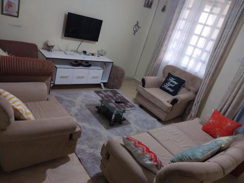 un soggiorno con divani e TV a schermo piatto di Nova suite a Eldoret