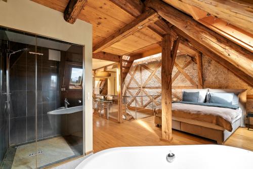 A&Y Oldtown Penthouse Loft Luzern في لوتزيرن: غرفة نوم مع سرير وحوض استحمام في غرفة