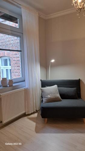 a blue couch in a room with a window at small Stable - charmantes Häuschen Mitten in Lemgo in Lemgo