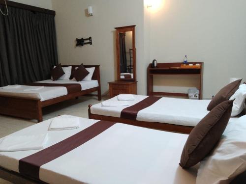 a hotel room with two beds and a mirror at MercuryFM 103 Guest House - Colombo 3 in Colombo
