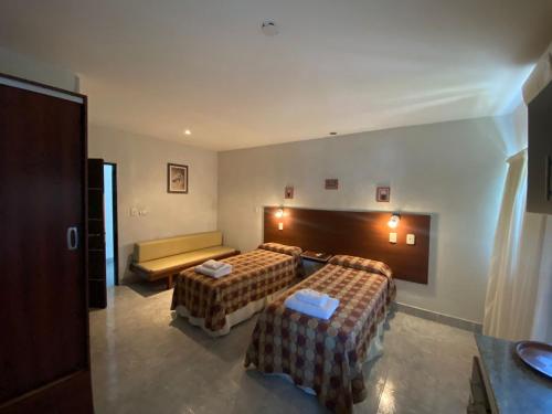 Habitación de hotel con 2 camas y sofá en Apart Hotel Río Dulce en Termas de Río Hondo